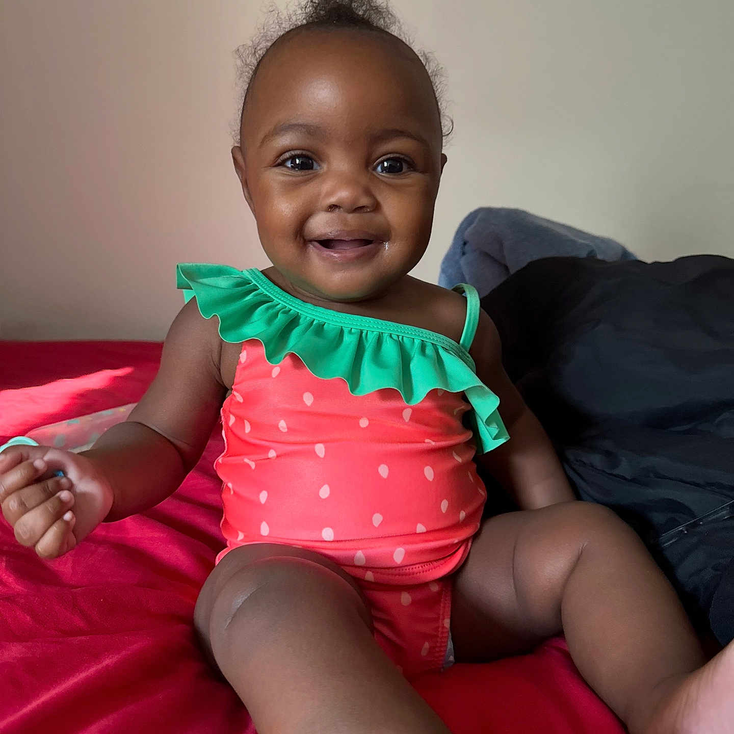 Niyah joined the competition — help win amazing prizes! baby, bed, blanket, bright_colors, child, cozy, cute, face, foot, hand, happy, indoor, person, portrait, sitting, skin, smiling, swimsuit, toddler, young_child