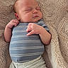 baby, newborn, sleeping, infant, blanket, soft_texture, clothing, striped_shirt, cozy, peaceful, cute, human, portrait, skin, hand, face, rest, comfort, lying_down, indoors