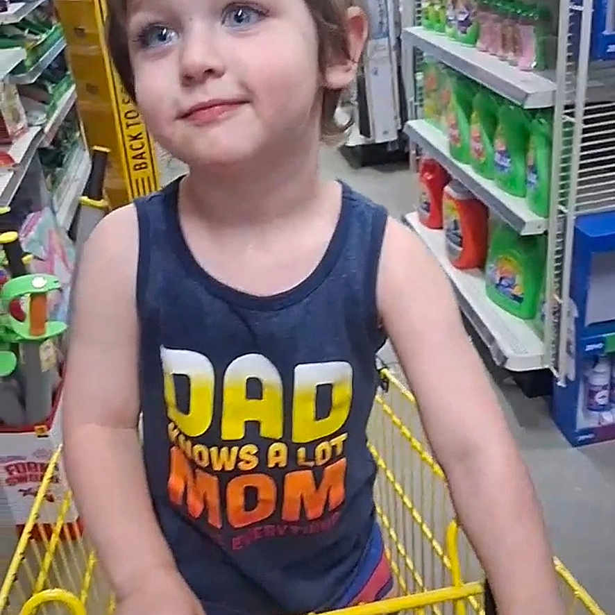 Danny is registered to the contest to win money with this photo: blue_eyes, casual_clothing, child, colorful_shorts, grocery_store, happy, household_products, indoor, person, portrait, retail, shelves, shopping, shopping_cart, smiling, store_aisle, tank_top, tousled_hair, yellow_cart, young_child