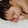baby, sleeping, infant, close_up, face, hand, skin, hair, pillow, rest, peaceful, cute, child, newborn, soft, natural_light, portrait, relaxation, fingers, person