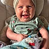 baby, smiling, headband, blanket, green_shirt, cushion, happy, infant, cute, indoor, child, portrait, fuzzy_blanket, seated, clothing, baby_girl, expression, headwear, comfort, closeup