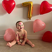 Gabriel a rejoint le concours — aidez-le/la à gagner de superbes lots ! child, baby, infant, balloons, heart_balloon, gold_balloon, number_balloon, number_7, kiss_marks, lipstick_marks, diaper, sitting, smile, floor, wall, celebration, birthday, party, joy, cute