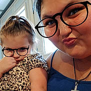 Emily is registered to the contest to win money with this photo: child, woman, glasses, freckles, leopard_print, dress, indoor, selfie, portrait, face, hair, skin, expression, cute, playful, digital_art, necklace, cross, window, light