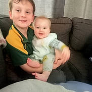 Cody joined the competition — help win amazing prizes! child, baby, couch, smile, indoor, holding, sibling, happy, face, person, clothing, curtain, furniture, cozy, cute, infant, young, family, portrait, casual