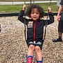 child, kid, swing, playground, spiderman_boots, rain_boots, just_do_it_jacket, curly_hair, smile, chains, wood_chips, fence, park, bench, adult_arm, outdoor, portrait, happy, casual_clothing, person