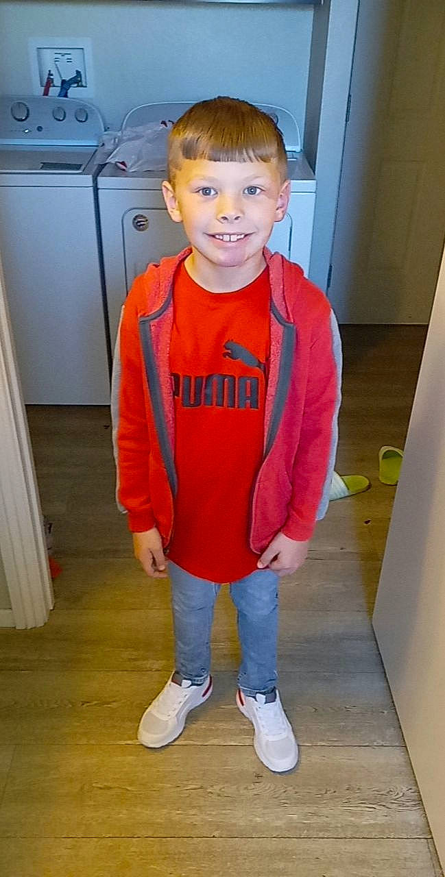 Emmet is registered to the contest to win money with this photo: baby_toddler_clothing, cabinetry, child, cooktop, eye, face, flooring, gas, gas_stove, happy, head, joy, kitchen_appliance, kitchen_stove, person, sleeve, smile, standing, stove, t_shirt