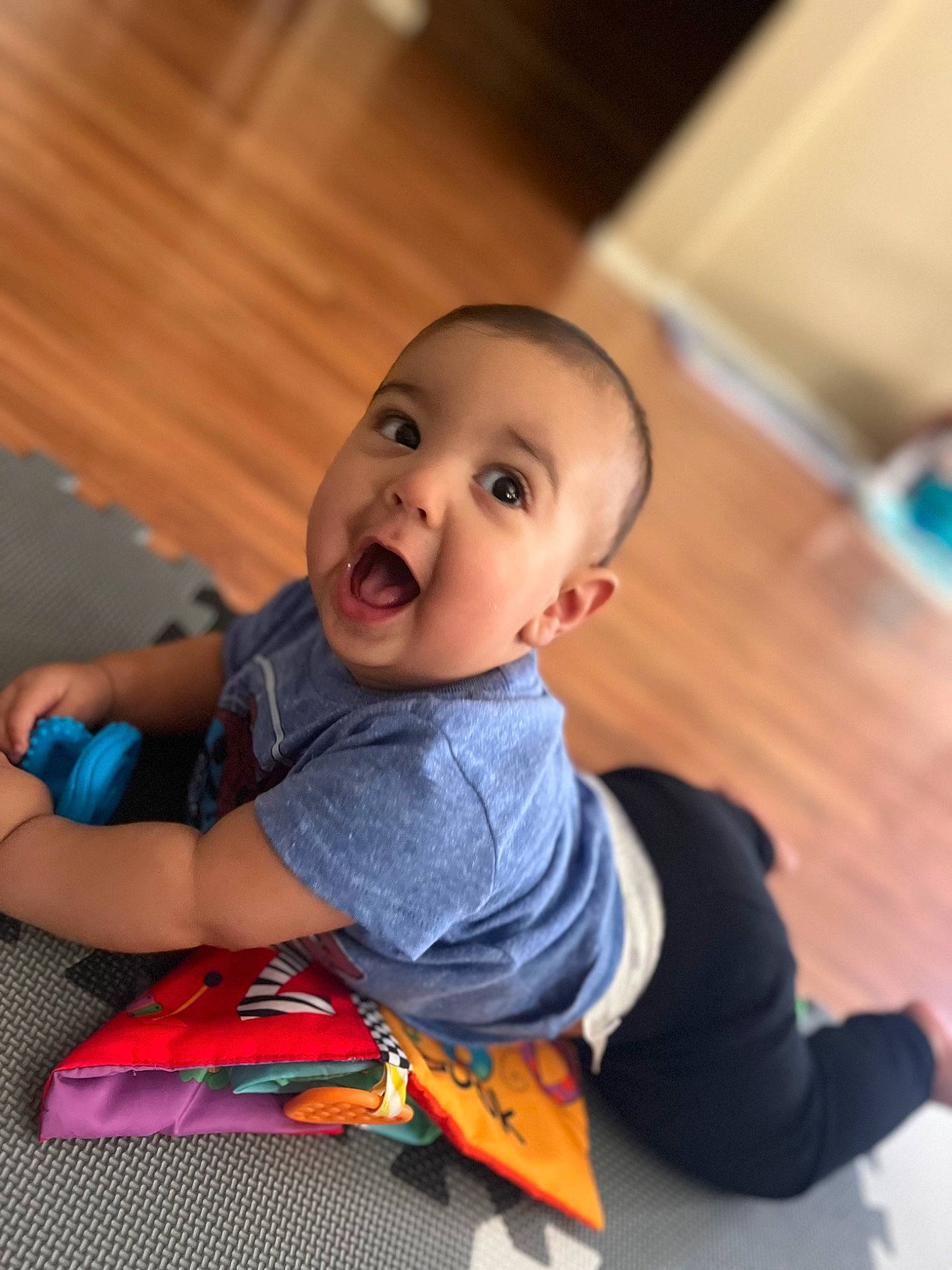 Khalil joined the competition — help win amazing prizes! baby, baby_toddler_clothing, child, comfort, elbow, face, floor, flooring, happy, hardwood, human_leg, knee, leisure, person, sitting, sleeve, smile, sock, surprise, t_shirt