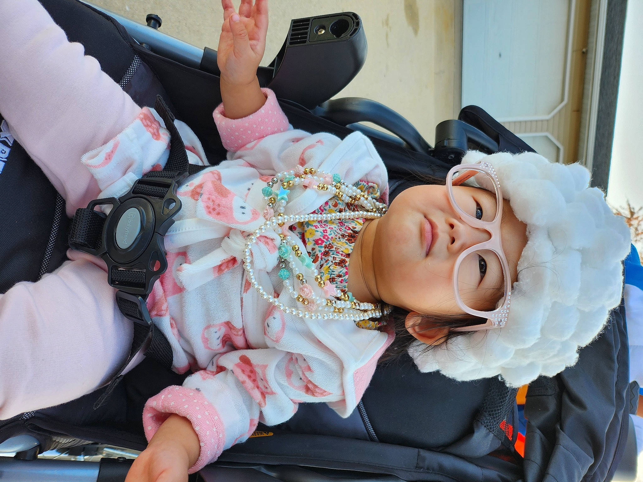 Eleanor is registered to the contest to win money with this photo: arm, auto_part, baby, baby_carriage, baby_products, car_seat, child, comfort, costume, event, fun, hand, headwear, luxury_vehicle, motor_vehicle, person, room, sitting, steering_wheel, toddler