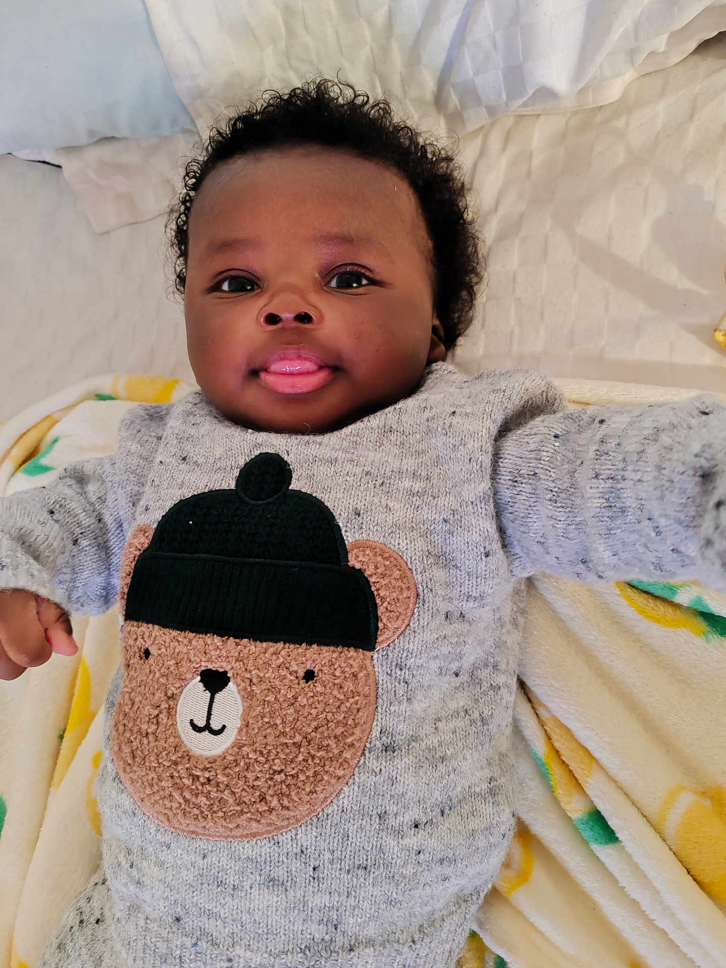 Nathan a rejoint le concours — aidez-le/la à gagner de superbes lots ! baby, infant, child, cute, smiling, tongue_out, curly_hair, sweater, bear_design, knitwear, blanket, soft_texture, lying_down, indoors, portrait, adorable, happy, face, closeup, cozy