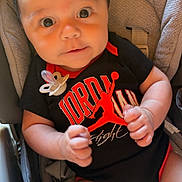 Aaron participe au concours pour gagner de l'argent avec cette photo : baby, infant, child, car_seat, onesie, black_clothing, red_clothing, pacifier, cute, wide_eyes, hands, indoor, seatbelt, portrait, human, young_child, soft_lighting, clothing, baby_fashion, expression