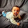 baby, child, infant, face, eyes, shirt, jeans, hand, bed, blanket, couch, indoor, portrait, cute, expression, skin, person, young, lying_down, curious