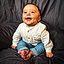 baby, child, smiling, happy, sitting, jeans, shirt, barefoot, indoor, portrait, cute, infant, young, clothing, person, face, hands, feet, background, studio