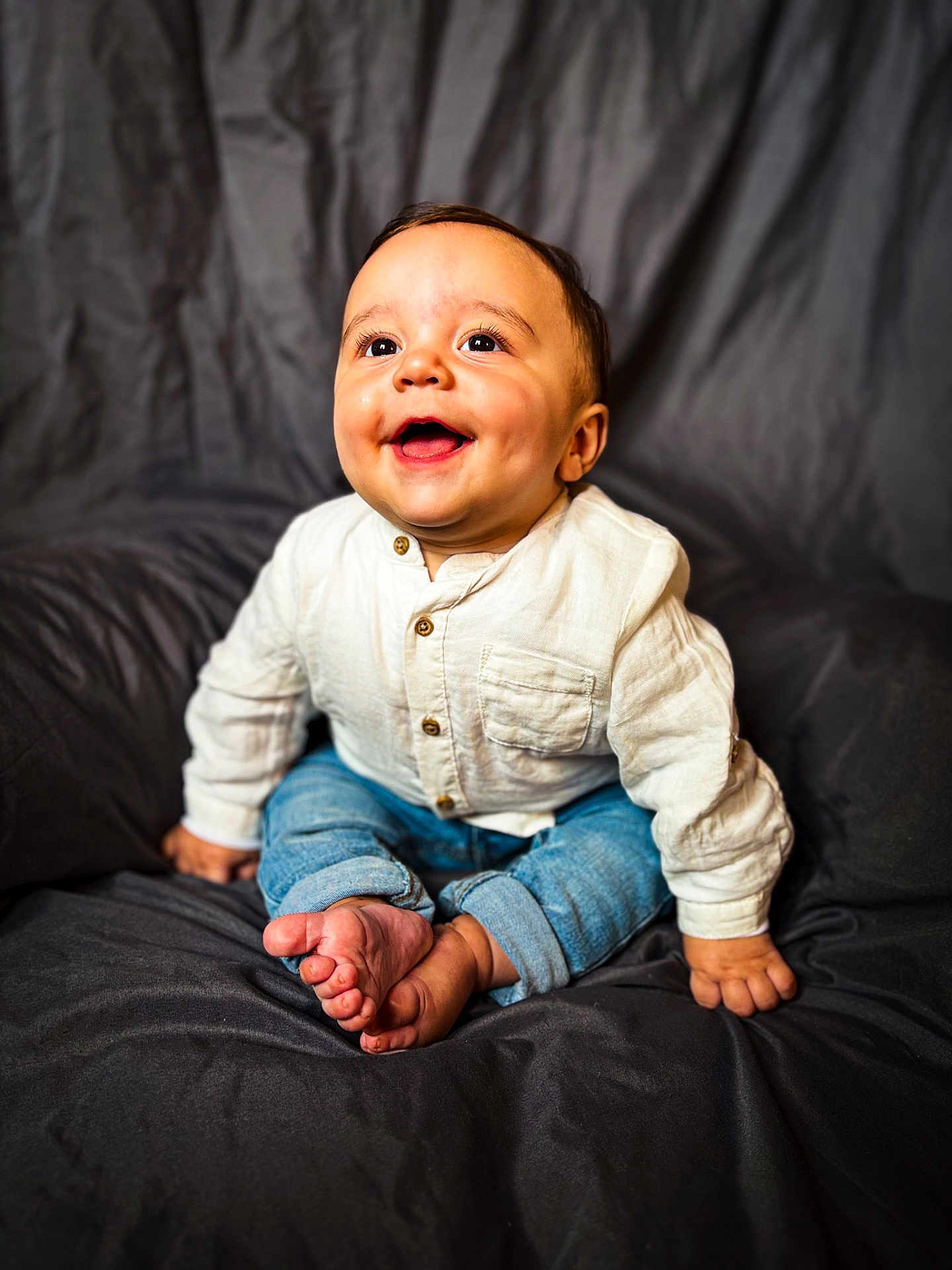 Aaron participe au concours pour gagner de l'argent avec cette photo : baby, child, smiling, happy, sitting, jeans, shirt, barefoot, indoor, portrait, cute, infant, young, clothing, person, face, hands, feet, background, studio