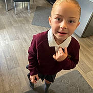 Rosie is registered to the contest to win money with this photo: blonde_hair, carpet, casual, child, curious, floor, furniture, girl, home, indoor, kitchen, light_skin, person, portrait, refrigerator, school_uniform, shorts, socks, standing, sweater