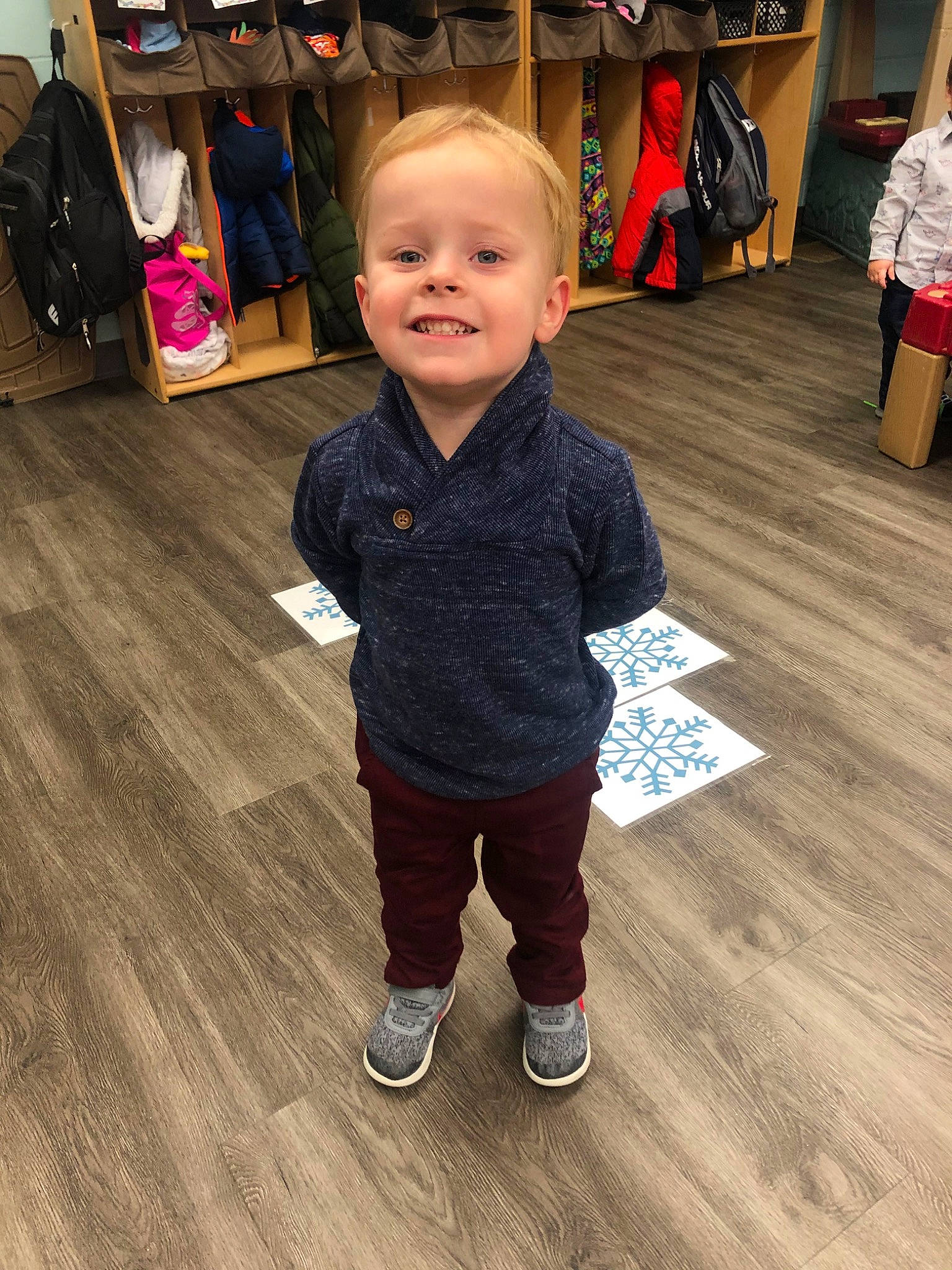 Henry is registered to the contest to win money with this photo: cheek, child, floor, flooring, footwear, fun, hardwood, head, joy, outerwear, person, play, shoe, skin, sleeve, smile, snapshot, standing, t_shirt, toddler