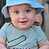 Julyan is registered to the contest to win money with this photo: adult, baby, blue_hat, child, closeup, cute, expression, face, hands, happy, headwear, holding, human, infant, outdoor, person, playful, portrait, smiling, striped_shirt