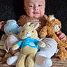 Julyan joined the competition — help win amazing prizes! baby, child, plush_toy, stuffed_animal, bunny, teddy_bear, blue_bear, couch, blanket, indoor, clothing, sitting, striped_pants, brown_shirt, person, cute, smiling, soft_toys, home, cozy