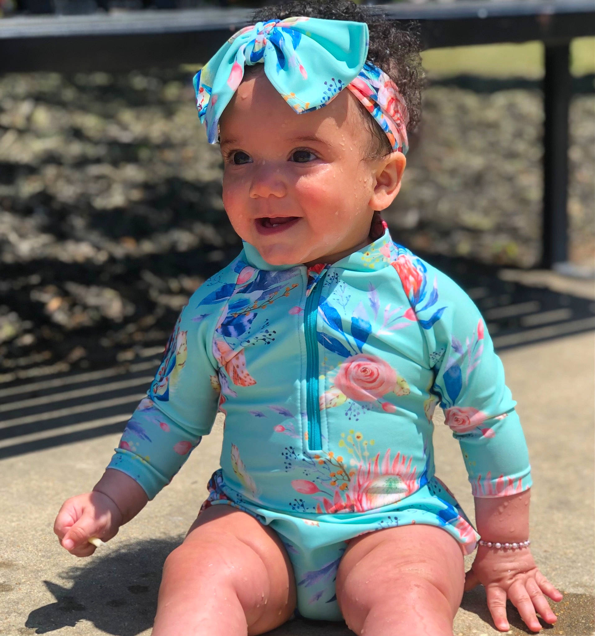 Clara is registered to the contest to win money with this photo: baby, baby_toddler_clothing, blue, cap, child, chin, electric_blue, eye, face, grass, happy, head, headwear, human_leg, person, personal_protective_equipment, photograph, pink, skin, sleeve