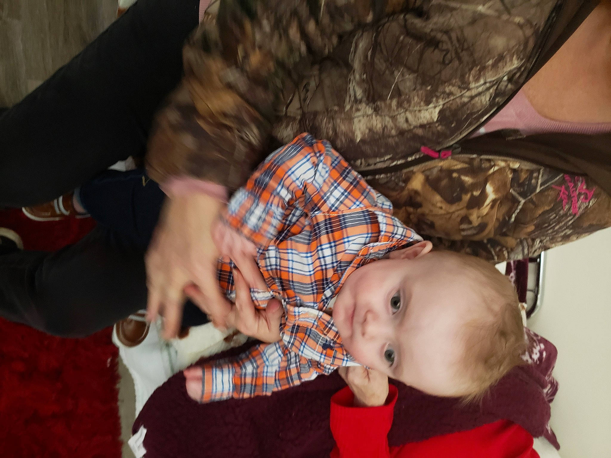 Nylles is registered to the contest to win money with this photo: baby, baby_toddler_clothing, black, camouflage, child, comfort, event, fun, gesture, lap, pattern, person, plaid, room, sitting, sleeve, tartan, textile, toddler, tree