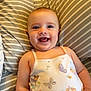 baby, smiling, infant, onesie, fairy, butterfly, pillow, striped, cute, happy, child, portrait, lying_down, indoors, soft_lighting, skin, face, arm, hand, baby_clothing
