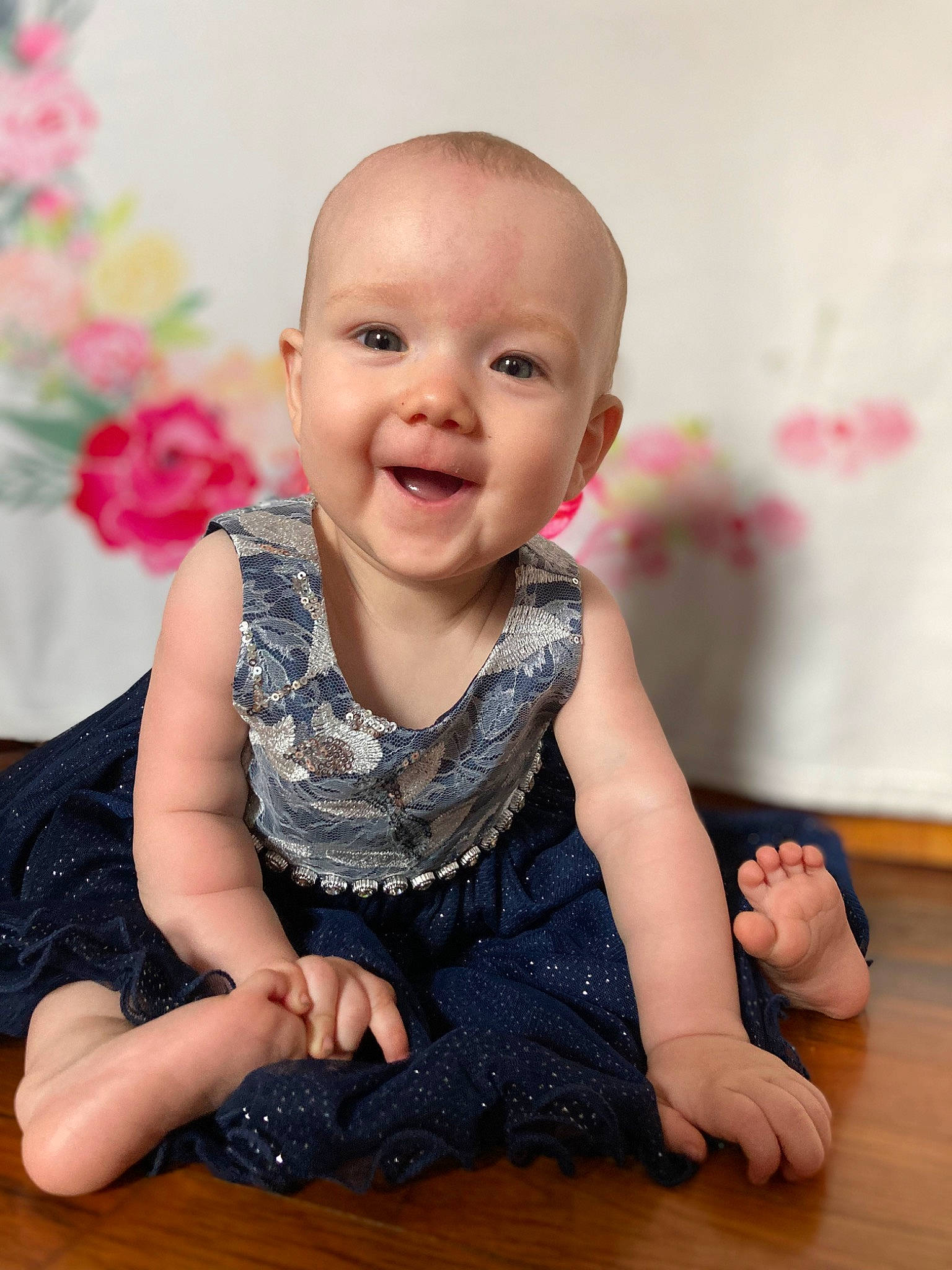 Alianna is registered to the contest to win money with this photo: arm, baby, baby_toddler_clothing, cheek, clothing, dress, flash_photography, flooring, flower, fun, happy, iris, person, pink, plant, skin, sleeve, smile, standing, toddler