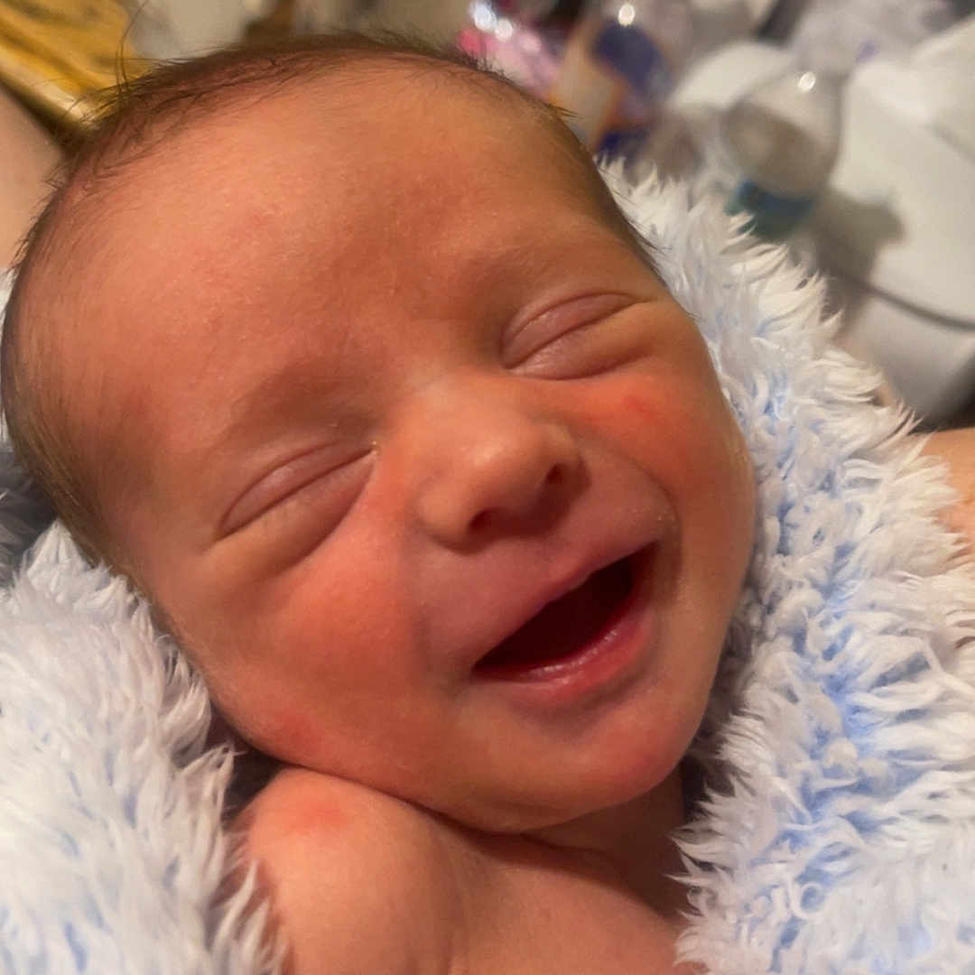 Bryler is registered to the contest to win money with this photo: baby, blanket, child, closeup, cozy, cute, face, happy, human, indoors, infant, newborn, newborn_baby, portrait, resting, skin, sleepy, smiling, soft_texture, wrapped