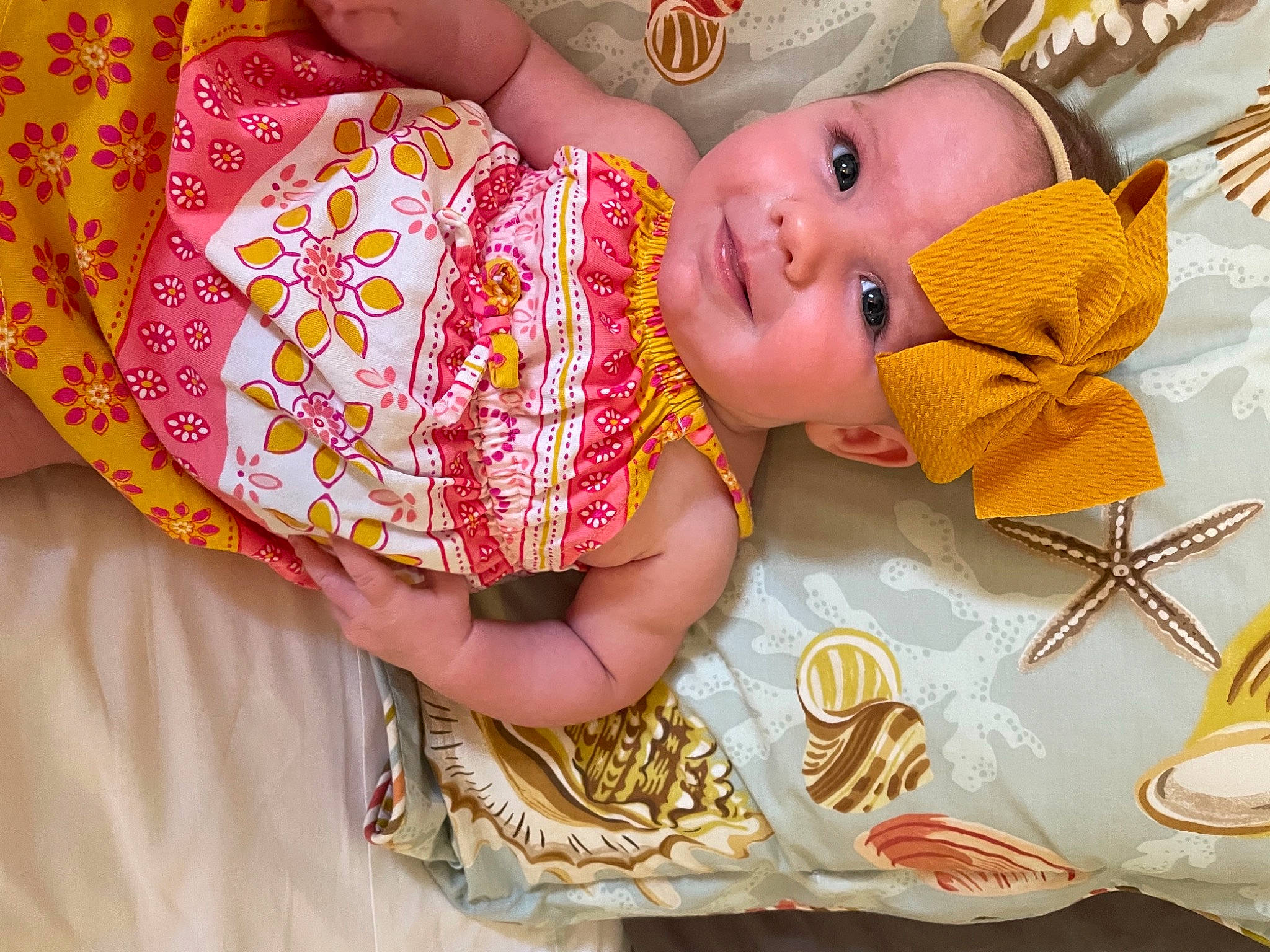 Gabby is registered to the contest to win money with this photo: baby, baby_toddler_clothing, beauty, cheek, child, design, eye, fashion_accessory, happy, head, headwear, linens, orange, organ, pattern, person, room, skin, textile, toddler