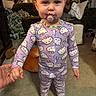 toddler, child, pajamas, hello_kitty, pacifier, beaded_necklace, hand_holding, barefoot, carpet, living_room, sofa, cushion, blanket, curtains, person, indoor, portrait, clothing, cute, baby