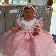 Syanna participe au concours pour gagner de l'argent avec cette photo : baby, child, pink_dress, headband, smiling, sitting, cushion, bench, lace, indoor, happy, portrait, clothing, fabric, furniture, person, cute, headwear, seat, infant