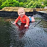Devin is registered to the contest to win money with this photo: baby, child, water, outdoor, nature, greenery, stone, crawling, smiling, happy, playful, sunlight, reflection, pool, shorts, shirt, infant, summer, garden, fun