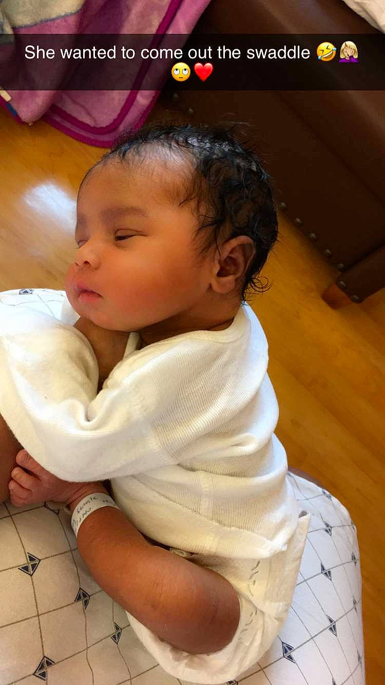 Aubree is registered to the contest to win money with this photo: baby, baby_toddler_clothing, cheek, child, chin, comfort, elbow, eyelash, flooring, hand, happy, human_body, mouth, neck, nose, person, sitting, skin, sleeve, thumb