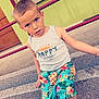 child, boy, sitting, steps, blue_eyes, tank_top, shorts, floral_pattern, sandals, outdoor, green_wall, red_railings, wooden_door, curious, casual_clothing, summer, portrait, daylight, happy_day, childhood
