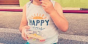 Léo participe au concours pour gagner de l'argent avec cette photo : child, boy, snack, sitting, steps, colorful_clothing, pineapple_pattern, tank_top, window, railing, outdoor, daylight, concrete, granite, expression, casual, shorts, food, holding, curious