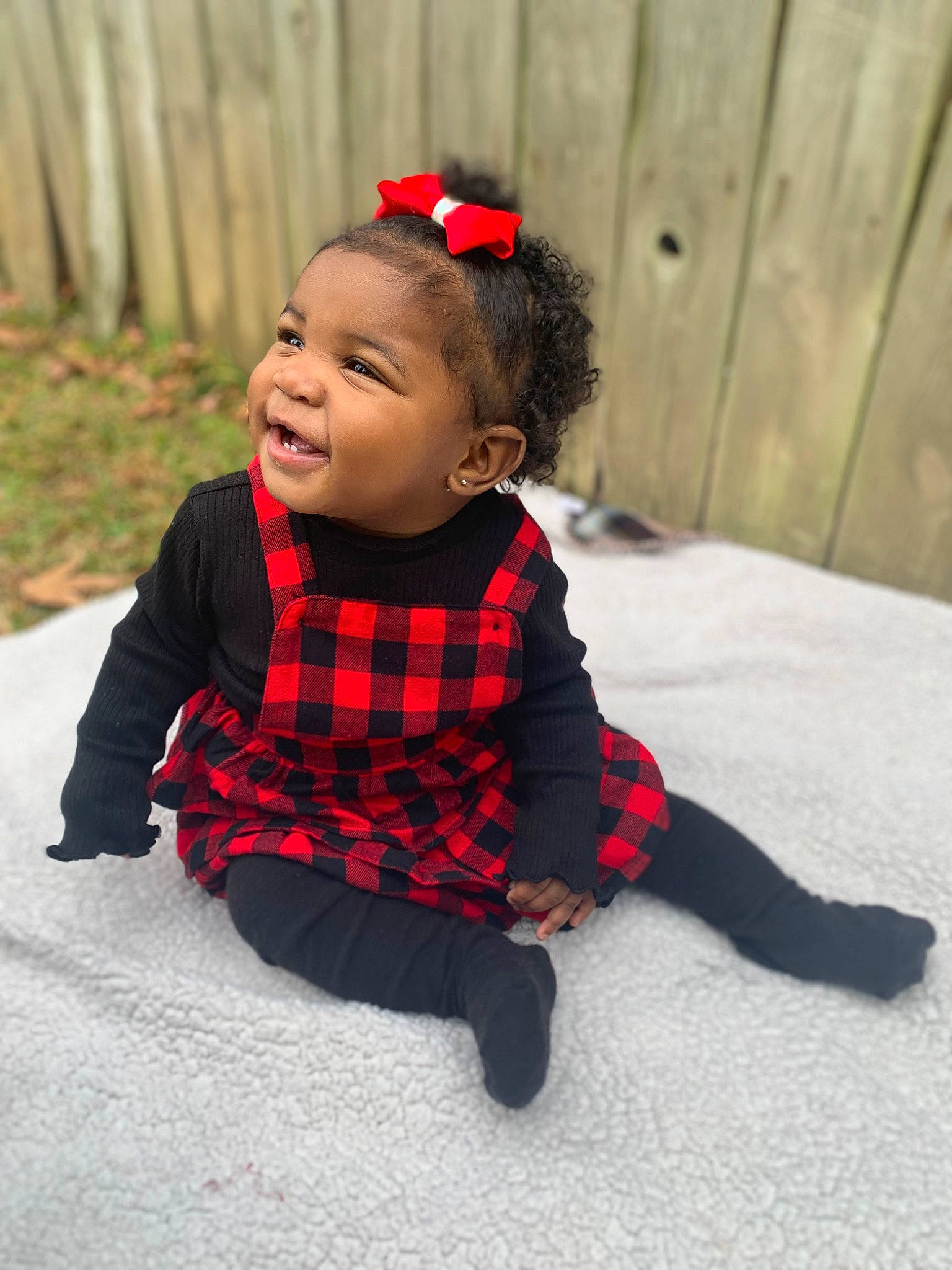 Brinleigh is registered to the contest to win money with this photo: baby, baby_toddler_clothing, child, clothing, costume, face, facial_expression, flooring, fun, grass, happy, outerwear, pattern, person, plaid, plant, sleeve, smile, tartan, toddler