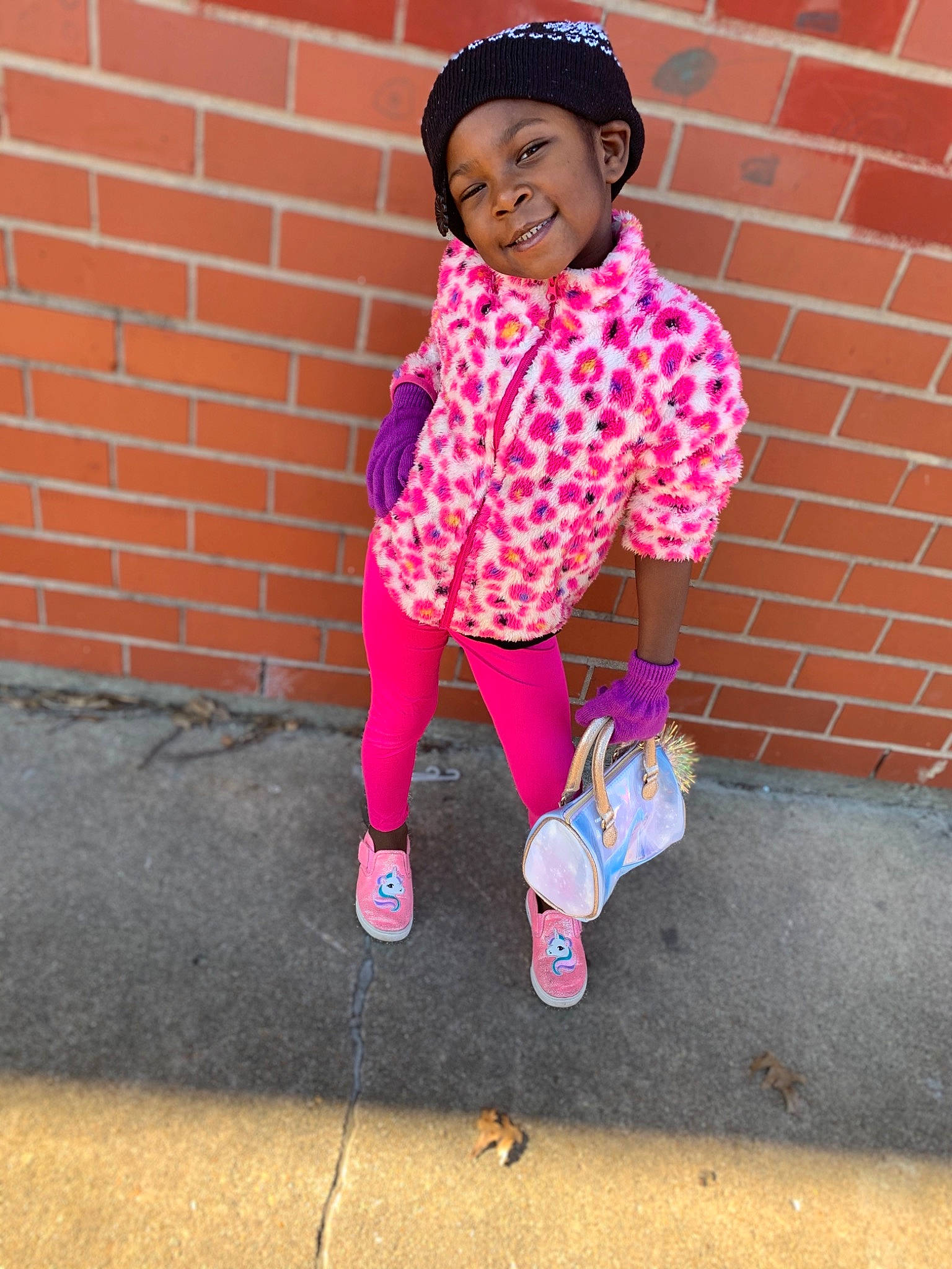 Azaria is registered to the contest to win money with this photo: baby_toddler_clothing, beanie, bonnet, brick, brickwork, cap, child_model, headwear, joy, knit_cap, magenta, person, pink, purple, toddler, walking_shoe