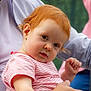 Thessa participe au concours pour gagner de l'argent avec cette photo : baby, child, red_hair, striped_shirt, person, adult_hand, outdoor, portrait, curious, skin, face, expression, holding, candid, casual_clothing, nature_background, closeup, young_child, human, arm