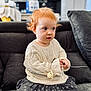 Thessa a rejoint le concours — aidez-le/la à gagner de superbes lots ! toddler, child, red_hair, sweater, pacifier, couch, indoor, curly_hair, knitwear, skirt, patterned_skirt, cushion, home, portrait, seated, looking_away, soft_lighting, innocence, casual, baby