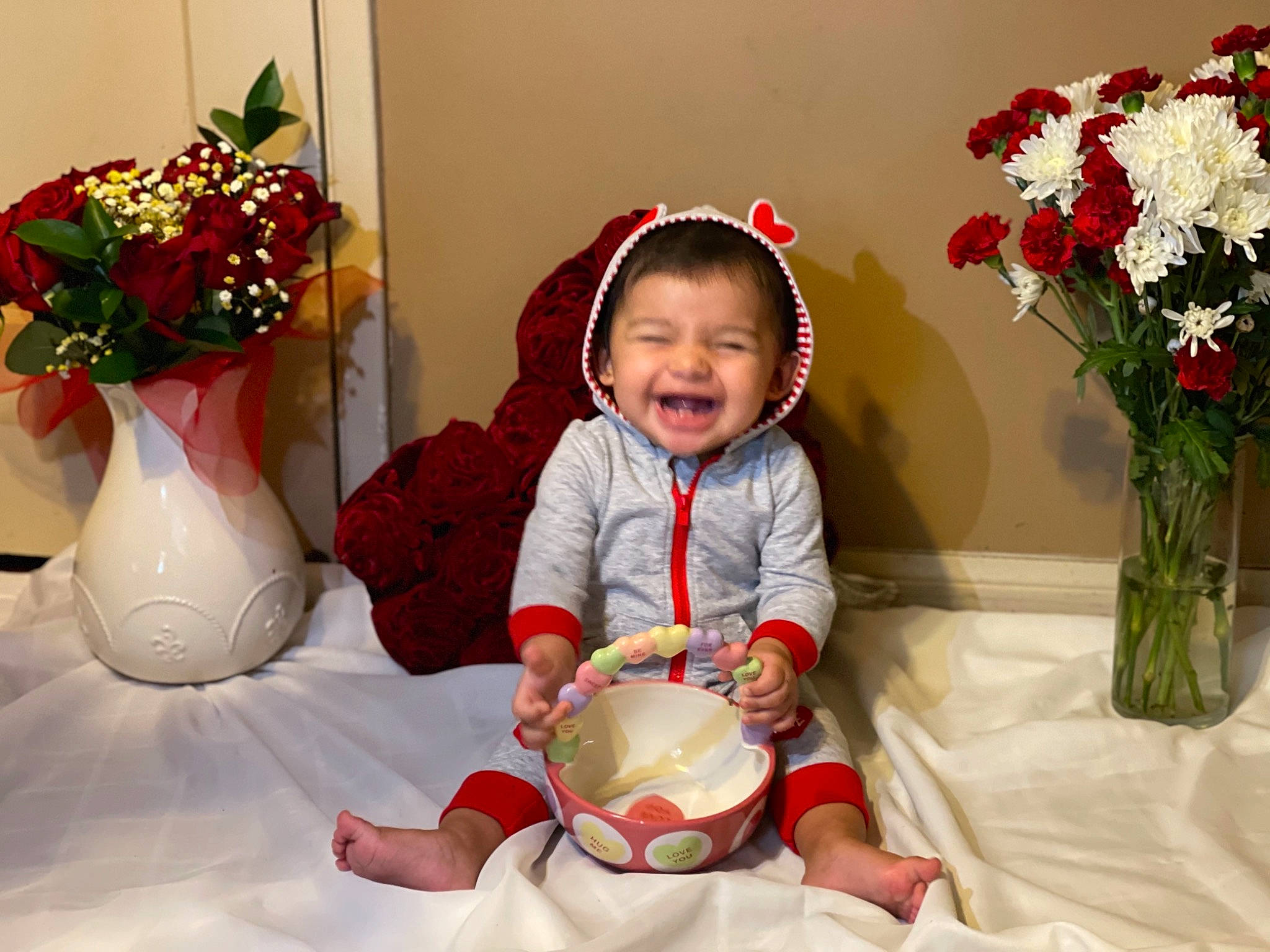 Itzel is registered to the contest to win money with this photo: baby, baby_toddler_clothing, comfort, facial_expression, flower, flower_arranging, flowerpot, happy, houseplant, human_body, people, person, photograph, pink, plant, red, smile, textile, toddler, vase