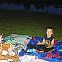 Mason joined the competition — help win amazing prizes! child, children, grass, blanket, stuffed_animals, water, evening, outdoor, toy, nature, person, playing, casual_clothing, dark, flash, curious_expression, sitting, recreation, relaxation, night