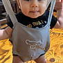 Eli joined the competition — help win amazing prizes! baby, child, indoor, floor, wooden_floor, baby_jumper, face, legs, black_tshirt, suspenders, furniture, curious, smile, standing, infant, cute, tongue, closeup, person, home