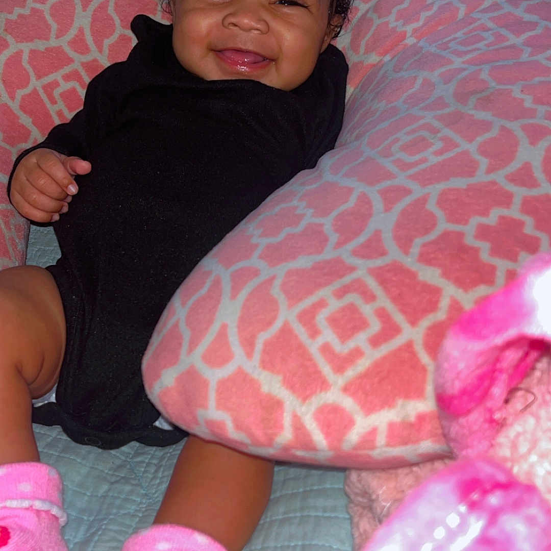 Jamya joined the competition — help win amazing prizes! baby, bed, bodypart, clothing, couch, cushion, face, finger, furniture, hand, happy, head, homedecor, hosiery, indoors, person, photography, portrait, smile, sock