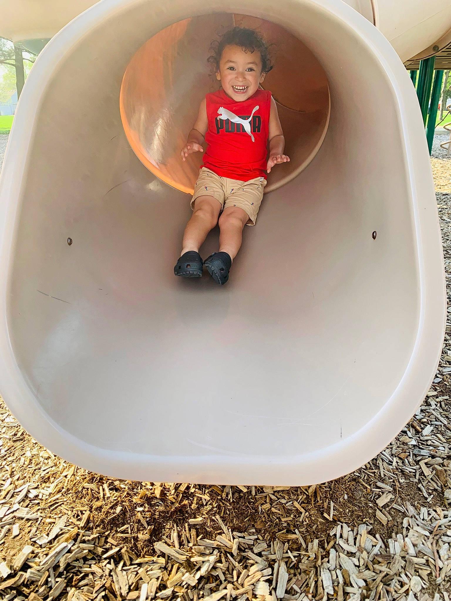 Fabian is registered to the contest to win money with this photo: baby_toddler_clothing, child, chute, circle, comfort, fun, grass, hat, human_leg, joy, leisure, outdoor_play_equipment, person, play, recreation, shorts, sleeve, sneakers, stairs, t_shirt
