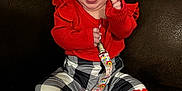 Celene is registered to the contest to win money with this photo: baby, smiling, sitting, red_clothing, patterned_pants, pacifier, pacifier_clip, happy, infant, indoor, couch, furniture, playful, tongue_out, cute, child, person, cozy, bright_colors, portrait