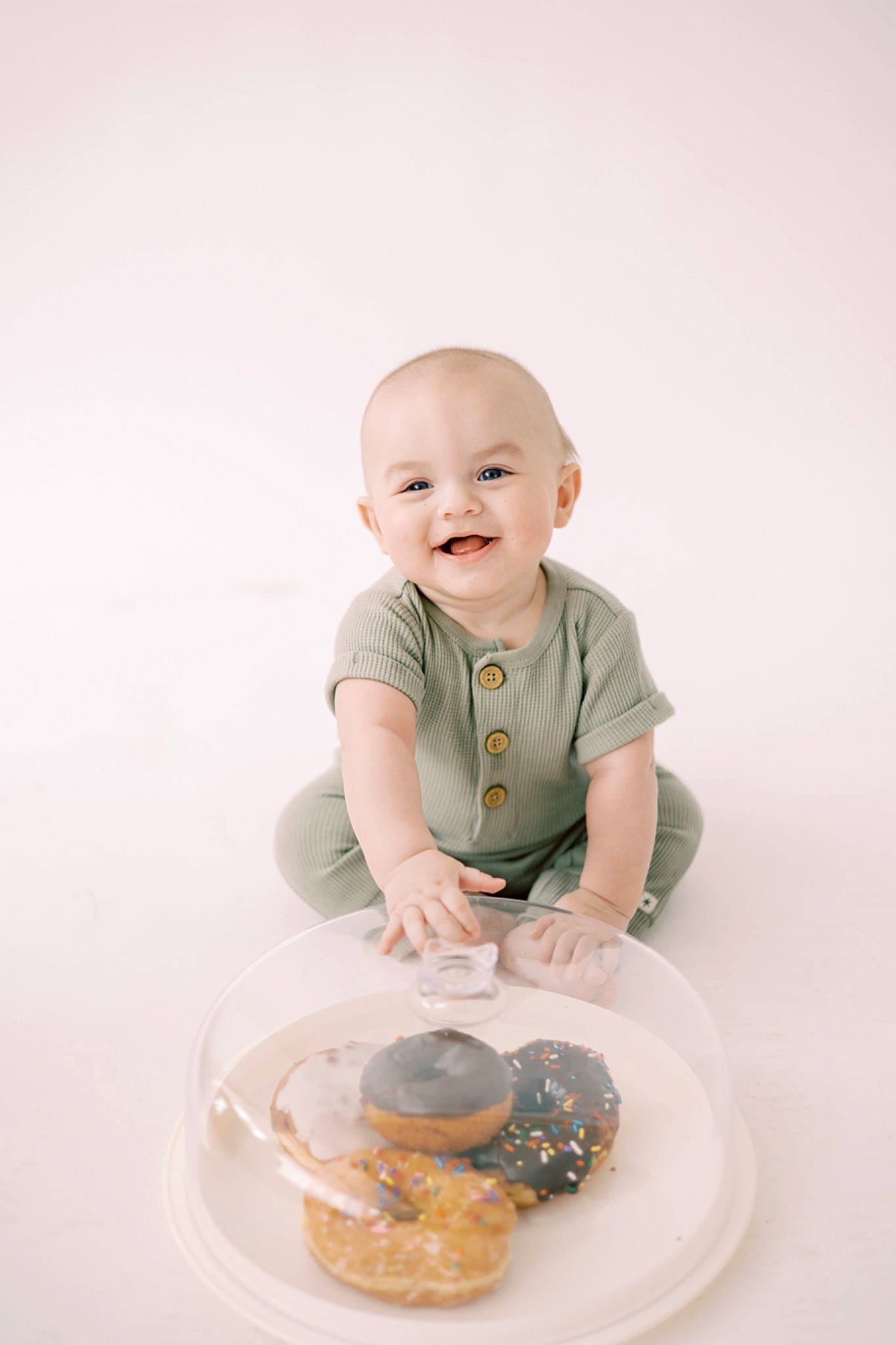 Reece is registered to the contest to win money with this photo: arm, baby, baby_toddler_clothing, ceramic, child, circle, comfort_food, dishware, food, fun, happy, human_body, joy, person, plate, sitting, sleeve, smile, t_shirt, table