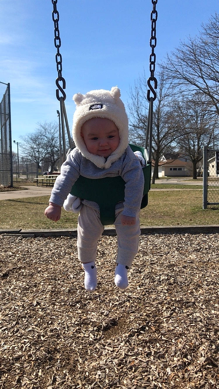 Reece is registered to the contest to win money with this photo: baby, baby_toddler_clothing, child, city, fun, grass, happy, headwear, leisure, people_in_nature, person, playground, public_space, recreation, sky, sleeve, smile, soil, swing, toddler