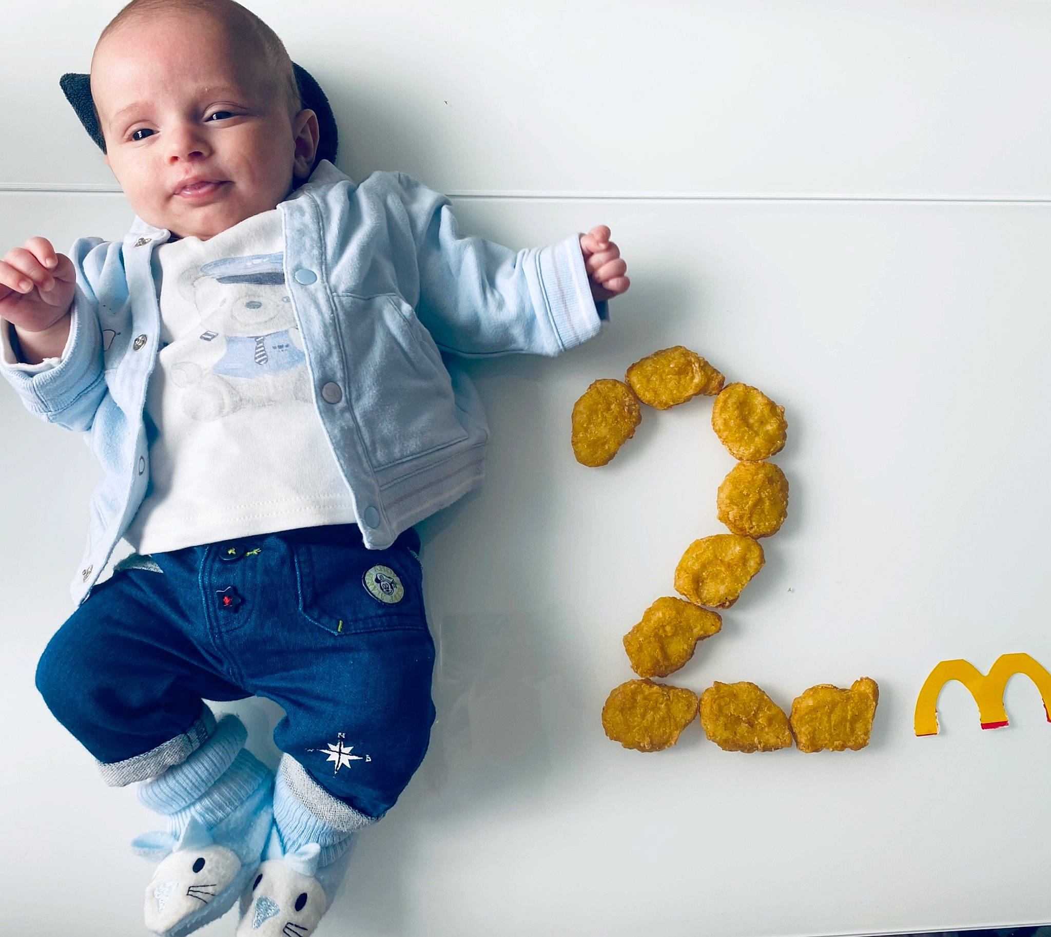 Lyo a rejoint le concours — aidez-le/la à gagner de superbes lots ! baby, baby_toddler_clothing, child, denim, electric_blue, face, fashion_accessory, finger, font, gesture, happy, pattern, person, sleeve, smile, t_shirt, thumb, toddler, toy, white