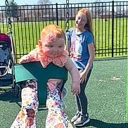 Kiana is registered to the contest to win money with this photo: baby, chain, child, fence, floral_pants, girl, grass, happy, headband, outdoor, park, playground, portrait, redhead, shoes, smile, stroller, sunny, swing, toddler