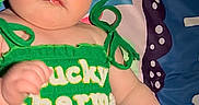 Kiana is registered to the contest to win money with this photo: baby, blue_eyes, bow, child, chubby_cheeks, closeup, fabric, green_dress, hand, headband, infant, lucky_charm_text, lying_down, numbers, pattern, playmat, portrait, sequin, st_patricks, tutu