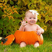 Gracie joined the competition — help win amazing prizes! baby, pumpkin, grass, flower_headband, autumn, leaves, child, cute, smiling, waving, outdoor, nature, seasonal, holiday, headband, sitting, orange, green, playful, portrait