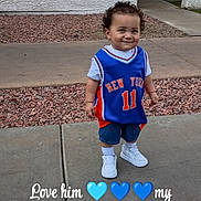 Adrian is registered to the contest to win money with this photo: child, boy, smile, sidewalk, blue_jersey, sneakers, curly_hair, outdoor, urban, concrete, gravel, wall, casual_clothing, portrait, cute, happy, standing, person, daylight, text_overlay